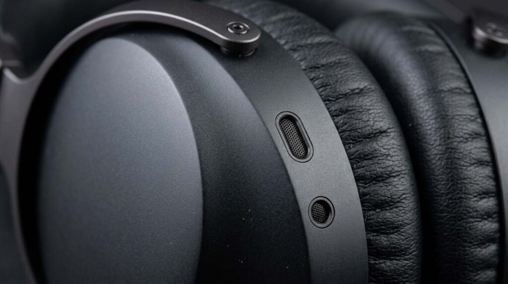 Headphone ear cup with noise cancellation microphone ports
